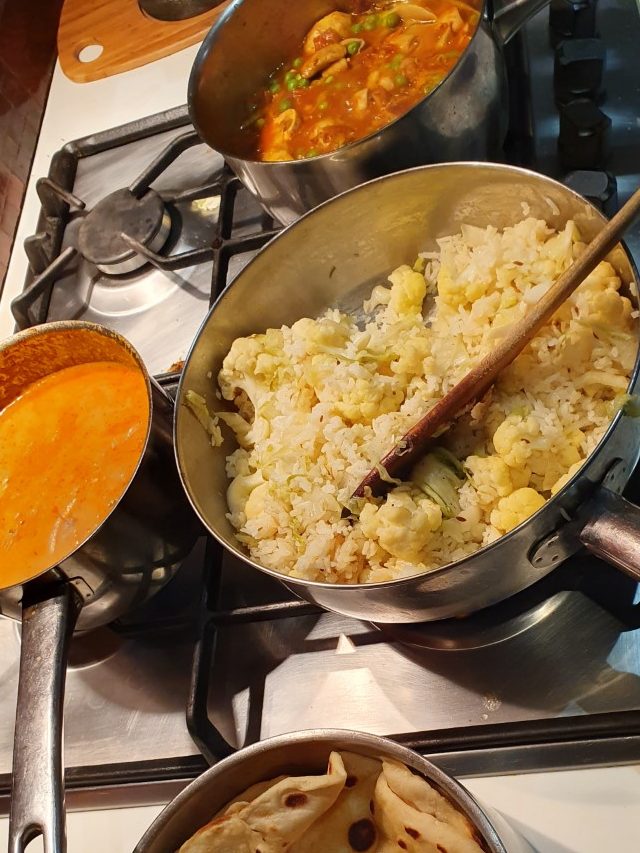 Indian meal being prepared on a stove-top. 